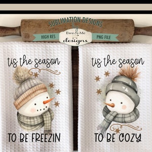 Pode incluir: Duas toalhas de cozinha brancas com um desenho de boneco de neve em aquarela. As toalhas apresentam o texto "tis the season" e as frases "to be freezin" e "to be cozy".