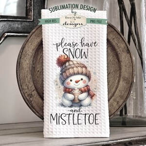May include: White kitchen towel featuring a watercolour illustration of a snowman holding a cup of hot chocolate. The text "please have snow -and- mistletoe" is printed on the towel.