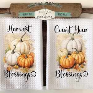 May include: Two white kitchen towels with a fall theme. One towel features a white pumpkin with the text "Harvest Blessings" and the other towel features a white pumpkin with the text "Count Your Blessings".