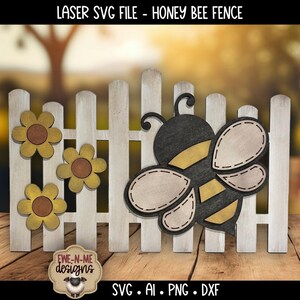 May include: A wooden fence with a honey bee and sunflower cutouts. The bee is black, yellow, and beige. The sunflowers are yellow and brown. The fence is white. Text on the image reads "LASER SVG FILE - HONEY BEE FENCE" and "EWE-N-ME designs".