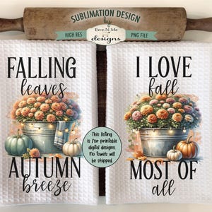 Puede incluir: Dos toallas de cocina blancas con diseños de temática otoñal. La primera toalla presenta un cubo de flores de otoño con una cadena de luces, calabazas y el texto "Falling leaves Autumn breeze". La segunda toalla presenta un cubo de flores de otoño con una cadena de luces, calabazas y el texto "I love fall Most of all".