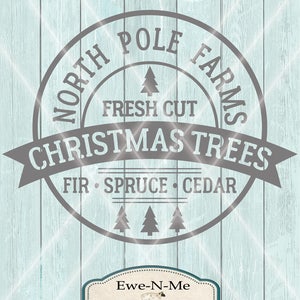Op de afbeelding: Een grijs en wit logo voor North Pole Farms Kerstbomen. Het logo heeft een cirkel met de tekst "North Pole Farms" en "Christmas Trees" in een groot lettertype. De tekst "Fresh Cut" verschijnt in een kleiner lettertype boven de tekst "Christmas Trees". De tekst "Fir Spruce Cedar" verschijnt in een kleiner lettertype onder de tekst "Christmas Trees". Een kleine boomgrafiek verschijnt boven de tekst "Fresh Cut" en drie kleine boomgrafieken verschijnen onder de tekst "Fir Spruce Cedar". Het logo bevindt zich op een lichtblauwe houtnerf achtergrond. Een kleine witte schapengrafiek verschijnt in een wit rechthoek met de tekst "Ewe-N-Me designs" onder de schapengrafiek.