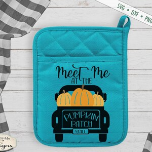 May include: A turquoise pot holder with a black truck carrying pumpkins and the text "Meet me at the pumpkin patch y'all".