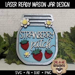 May include: A blue mason jar design with a silver lid and a white background. The jar has the words "Strawberry Patch" written on it in white lettering. There are three red strawberries and three yellow flowers on the jar.