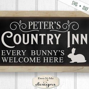 Puede incluir: Un letrero en blanco y negro con el texto "Peter's Country Inn" y "Every Bunny's Welcome Here". Una silueta de conejo blanco est&aacute; en el lado derecho del letrero.