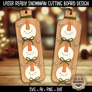 May include: Two wooden cutting boards with a snowman design. Each board features three snowman faces with orange carrot noses, black dot eyes, and green bow ties. White snowflakes and a green twine loop complete the design. The text "LASER READY SNOWMAN CUTTING BOARD DESIGN" is at the top.
