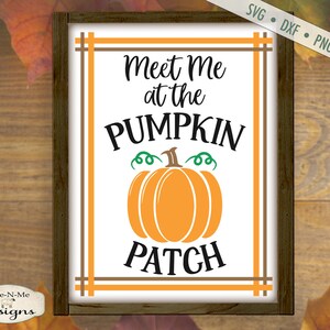 Pode incluir: Uma placa emoldurada com o texto "Meet Me at the Pumpkin Patch" em preto, com um gráfico de abóbora laranja. A placa tem uma moldura marrom e uma borda laranja e marrom. O fundo é uma superfície de madeira.