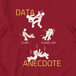 May include: Red t-shirt with a white graphic of stick figures fighting. The text "DATA IS NOT PLURAL FOR ANECDOTE" is written in yellow.