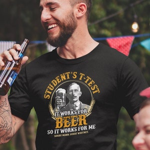 May include: A black t-shirt with a yellow circle graphic featuring a man holding a beer mug. The graphic text reads "Student's T-Test It Works For Beer So It Works For Me Sorry Mark Sorry Whitney".