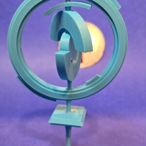May include: A blue 3D printed sculpture with a circular design and a base. The sculpture is made of multiple interlocking pieces.