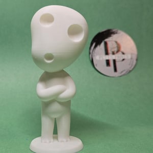 May include: White figurine of a character with three holes in its head, standing on a round base. The character has its arms crossed and is looking straight ahead.