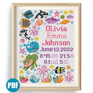 May include: A colorful cross-stitch pattern featuring a variety of sea creatures, including a whale, octopus, fish, and turtles. The pattern also includes the name "Olivia Emma Johnson", the date "June 12, 2022", and the time "8:45 am 21.5 in 8.1 lbs 5 oz".