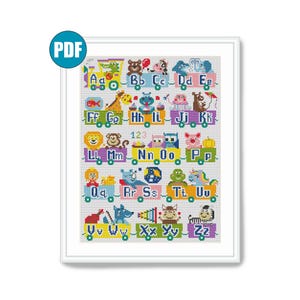 May include: A framed cross-stitch sampler featuring the alphabet with each letter displayed on a train car. Each car has a corresponding animal or object. The letters and images are in various colors, including blue, green, yellow, and pink.