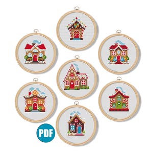 Op de afbeelding: Set van zeven kruissteekpatronen met gingerbread huisjes met snoepstokaccenten. Elk patroon wordt weergegeven in een houten borduurring.