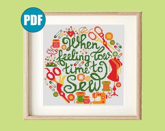 Peut inclure: Un motif de point de croix encadré avec le texte "When feeling low, time to sew". Le motif présente des outils de couture comme des ciseaux, des bobines de fil et une machine à coudre dans un arrangement circulaire. La palette de couleurs comprend le vert, le rouge, l'orange et le jaune.