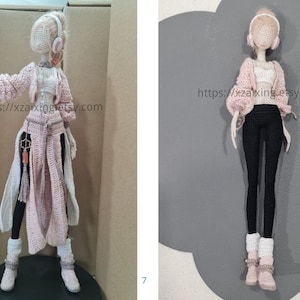 May include: Crocheted doll wearing a pink sweater, white top, black leggings, and white boots. The doll has headphones and a long, flowing coat. The doll is standing on a black surface. The Etsy shop URL is visible on the image.