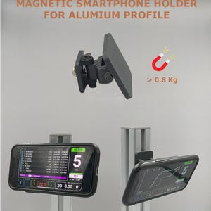 Könnte beinhalten: Schwarzer magnetischer Smartphone-Halter für Aluminiumprofile. Das Bild zeigt ein Smartphone, das an der Halterung befestigt ist und Daten anzeigt. Der Text auf dem Bild lautet "MAGNETIC SMARTPHONE HOLDER FOR ALUMIUM PROFILE" und "> 0.8 Kg".