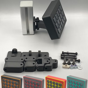 May include: An assortment of black and silver mechanical components, including a rectangular panel with 16 buttons. Additional parts include mounting brackets, screws, and colored button panels with orange, red, and green accents. The components appear to be for a custom controller.