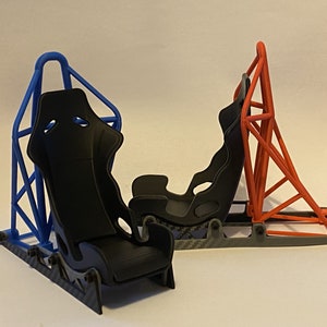May include: Two racing seats with black fabric and metal frames. One seat is blue and the other is orange.