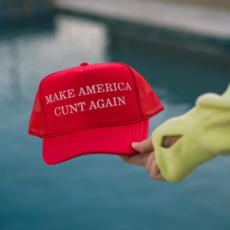 May include: Red mesh trucker hat with the text "MAKE AMERICA CUNT AGAIN" in white.