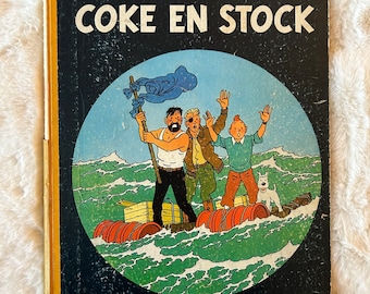 Les Aventures de Tintin: Coke en Stock autorstwa Hergé, pierwsze wydanie komiksu w twardej oprawie w języku francuskim, opublikowane w 1958 r. przez Casterman