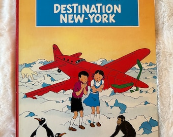 Les Aventures de Jo, Zette et Jocko : Destination New-York par Hergé, première édition de la bande dessinée à couverture rigide en français, publiée en 1951 par Casterman