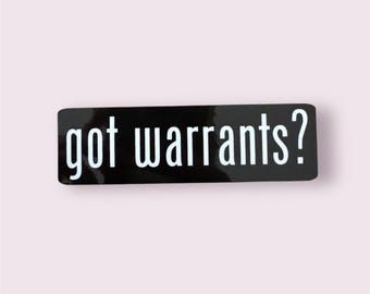 May include: A rectangular black sticker with the words "got warrants?" in white, sans-serif font. The sticker has a glossy finish and is set against a light pink background.