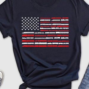 May include: A navy blue t-shirt with a white and red American flag design. The flag is made up of train silhouettes.