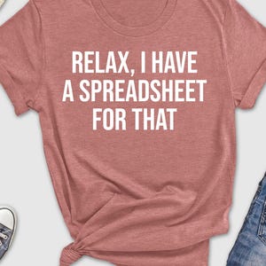 May include: A heather red t-shirt with the text "Relax, I have a spreadsheet for that" in white.