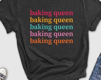 May include: A dark grey t-shirt with the text "baking queen" repeated five times in different colors. The text is stacked vertically down the center of the shirt.