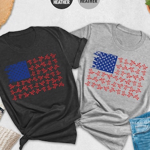 May include: Two t-shirts with a graphic of an American flag made of red, white, and blue stars. The t-shirts are available in dark heather grey and athletic heather.