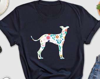 May include: A navy blue t-shirt with a floral patterned silhouette of a dog. The dog is white with colorful flowers and leaves.