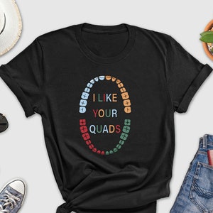 May include: Black t-shirt with a graphic of a circle of teeth with the text "I like your quads" in colorful letters.