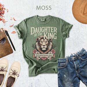 a variety of items, including a green t-shirt with a lion design, a hat, sunglasses, a notebook, a pair of shoes, and denim shorts, all arranged on a white background.