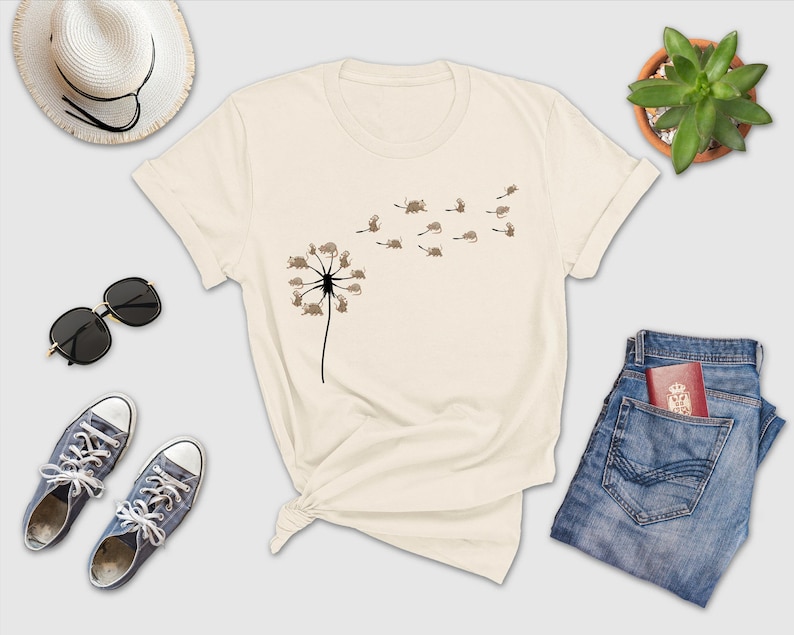 a t - shirt with a dandelion on it next to a pair of