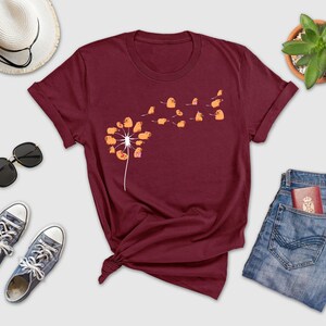 a t - shirt with a dandelion design on it