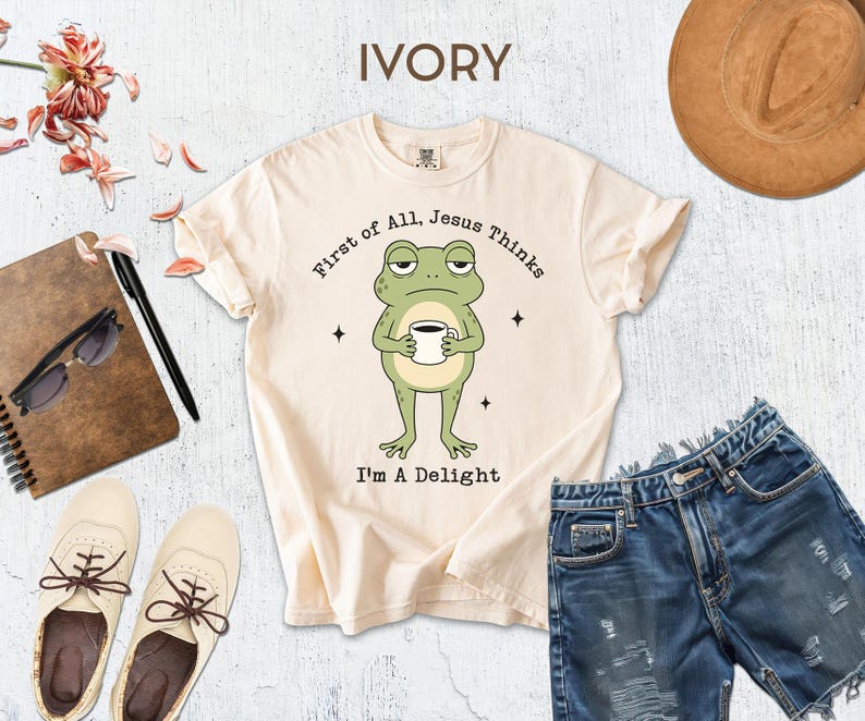 a white t-shirt with a cartoon frog holding a cup, a pair of blue jeans, a brown hat, sunglasses, a notebook, and a pair of white shoes.