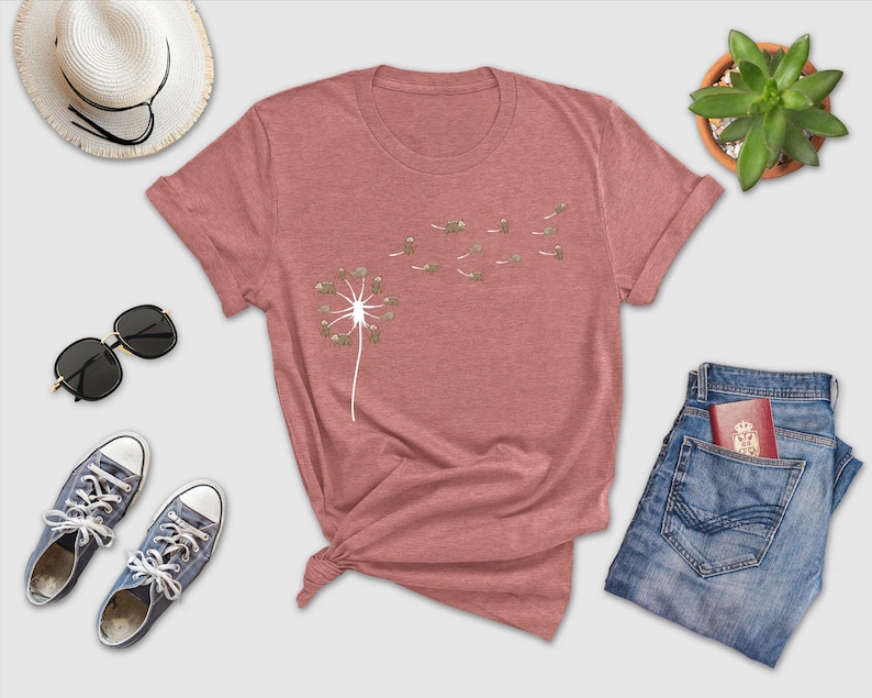 a t - shirt with a dandelion on it next to a pair of