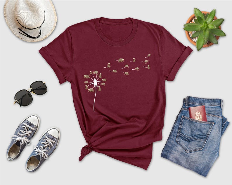 a t - shirt with a dandelion on it next to a pair of