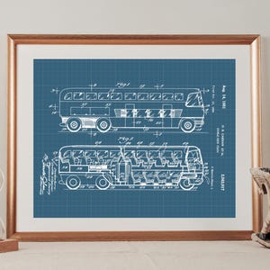 May include: A framed blueprint art print featuring white technical line drawings of a double-decker bus on a blue grid background. The print includes text labels such as Aug. 14, 1951, G.S. Caesar et al, and patent number 2,563,917.