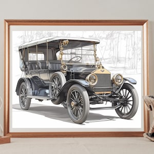 May include: Framed print of a vintage black car with gold accents. The classic automobile has a convertible top and spoked wheels. The artwork is displayed in a gold frame and rests on a light-colored surface.