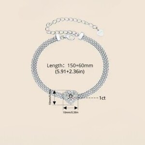 May include: Silver bracelet with a square-shaped cubic zirconia stone in the center. The bracelet is 5.91 inches long and has an adjustable extension chain. The stone is 1 carat.