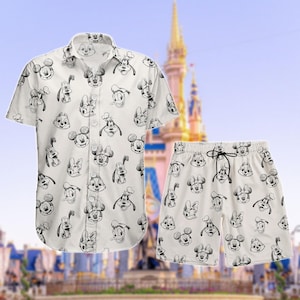 Puede incluir: Conjunto de camisa y pantalón corto blancos con un patrón repetido de caras de personajes de dibujos animados en blanco y negro. El pantalón corto tiene cintura con cordón. El fondo muestra un castillo.