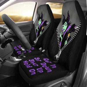 Puede incluir: Fundas de asiento de coche negras con una imagen de dibujos animados de Maléfica y un diseño de cremallera. Las fundas de los asientos tienen las frases "Get In, Sit Down, Shut Up, Hold On" en texto morado.