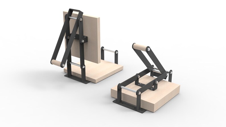 May include: Two wooden book presses with black metal frames. One press is upright, the other is lying down. Each press has a wooden handle and a wooden base. The presses are designed for bookbinding and crafting.