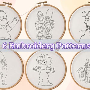 Puede incluir: Seis bastidores de bordado circulares de madera con tela blanca que presentan dibujos de líneas negras de personajes de Los Simpson. Los diseños incluyen a Homer, la familia completa, Homer en un seto, Marge, Maggie y Lisa tocando el saxofón.