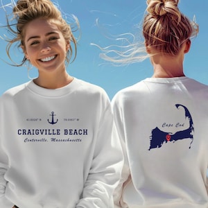 May include: White sweatshirt with a blue anchor and the text "Craigville Beach, Centerville, Massachusetts" on the front and a blue outline of Cape Cod with a red heart on the back.