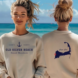 May include: A beige sweatshirt with a navy blue anchor and the text "OLD SILVER BEACH Falmouth, Massachusetts" on the front and a navy blue outline of Cape Cod with the text "Cape Cod" on the back.