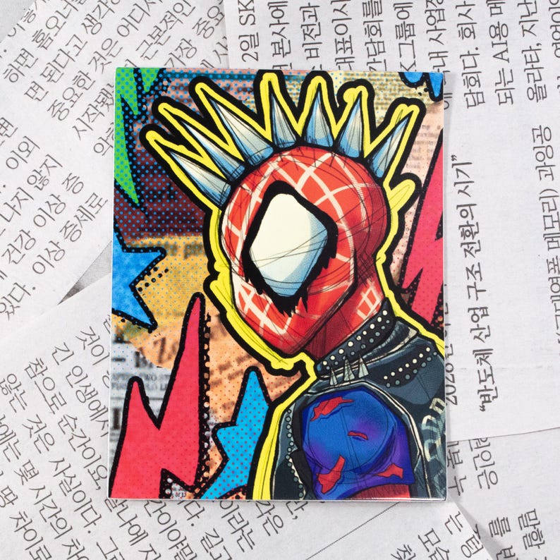 May include: A colourful sticker featuring a cartoon illustration of a superhero with a red and black suit, a mohawk, and a black leather jacket. The background is a collage of colourful comic book panels.