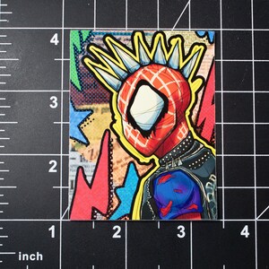May include: A colourful illustration of a cartoon superhero wearing a red and black suit with a spiky mohawk. The background is a collage of colourful geometric shapes and patterns.